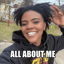 a woman wearing a black hoodie with the words all about me on it
