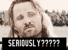 a man with long hair and a beard is making a serious face with the words seriously y ?