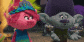 a couple of trolls standing next to each other and looking at each other .