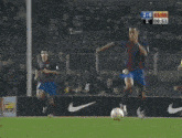 a soccer game is being played in front of an estrella damm banner