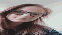 a woman wearing glasses looks at the camera