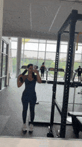 a woman is taking a picture of herself in a gym mirror