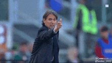 a man in a suit gives a thumbs up in front of a bt sport 3 live logo