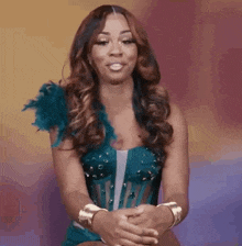 a woman is wearing a blue dress with feathers on the sleeves .
