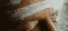 a close up of a man 's face with a white stripe on it