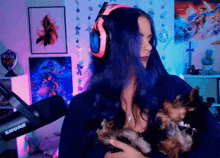 a woman wearing headphones holds a small dog in her arms in front of a shure microphone