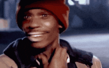 a close up of a man wearing a red beanie and a jacket .