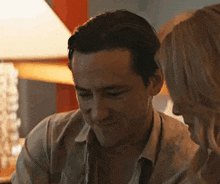 a man and a woman are looking at each other in a room .