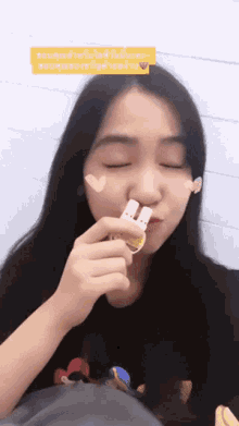 a woman with a heart on her face is holding a piece of candy