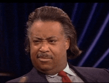 a man wearing a suit and tie making a funny face