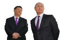 a man in a suit and tie stands next to another man in a suit