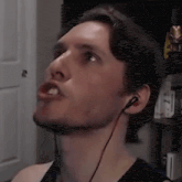 a man wearing headphones is making a funny face while looking up .