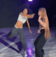 two women are dancing together in a dark room .