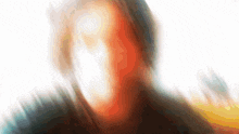 a blurry picture of a person 's face against a white backdrop