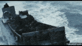 a boat filled with soldiers is floating in the ocean .