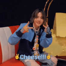 a person sitting on a couch with a sign that says cheese !!