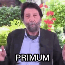 a man with a beard is wearing a suit and has the word primum on his chest