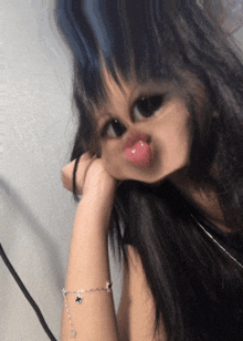a girl with a bracelet on her wrist makes a face