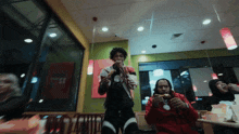 a man in a red jacket is eating a hamburger