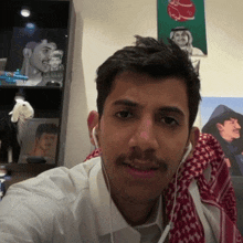 a man with a mustache wearing ear buds and a scarf