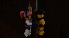 a man and a girl are hanging from a chain in a dark room