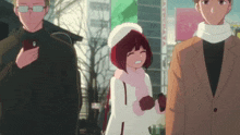 a man holding a cell phone stands next to a girl in a red hat