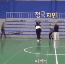 a group of people are playing a game of soccer on a court .
