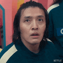 a man with long hair is wearing a green netflix uniform