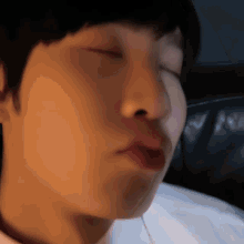 a close up of a person 's face with their eyes closed and red lips