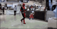 a person in a deadpool costume is walking down a hallway .