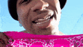 a close up of a man wearing a bandana and a hat
