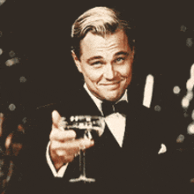 a man in a tuxedo is holding a champagne glass