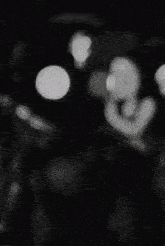 a black and white photo of a person 's face in a dark room .