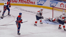 a hockey game is being played in front of a tim hortons ad