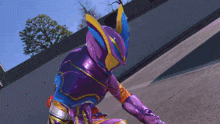 a person in a purple and blue superhero costume is kneeling down