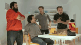 a group of men standing around a table with a chess board on it