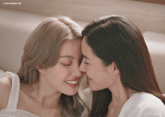 two women are touching their noses with a lingormgifss watermark