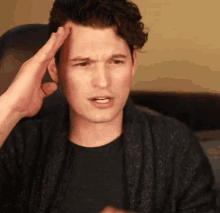 a man with a hand on his forehead making a face