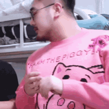 a man wearing glasses and a pink sweater that says " ham the piggy "