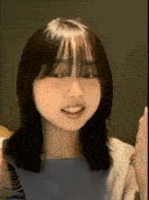 a close up of a woman 's face with her mouth open and a thumbs up