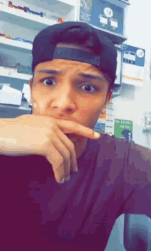 a man wearing a baseball cap and a black shirt looks at the camera