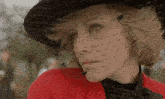 a close up of a woman wearing a hat and a veil on her face .