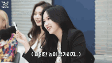 a group of girls are sitting in front of a sign that says twice on it