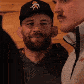 a man with a beard is wearing a hat with a cowboy on it