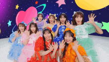 a group of girls in colorful dresses are waving
