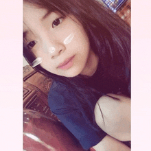 a young girl with a spoon in her nose takes a selfie