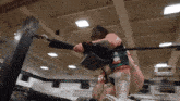 a woman in a green top is wrestling a man