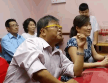 a group of people are sitting around a table with a box that says ' donation ' on it