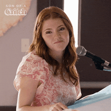 a woman stands in front of a microphone with the words son of a glitch on the bottom
