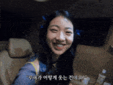 a woman sitting in the back seat of a car smiling